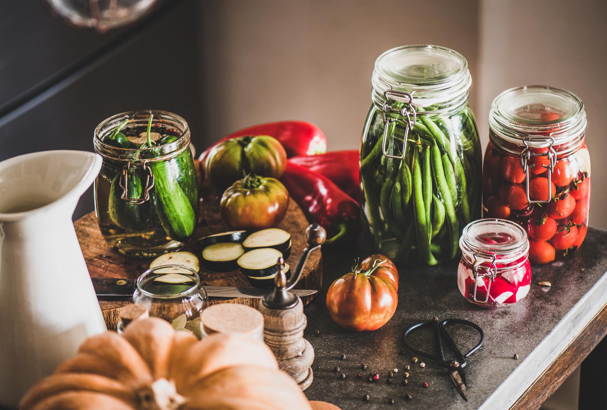 Small kitchen counter with jars of spices and fresh vegetables