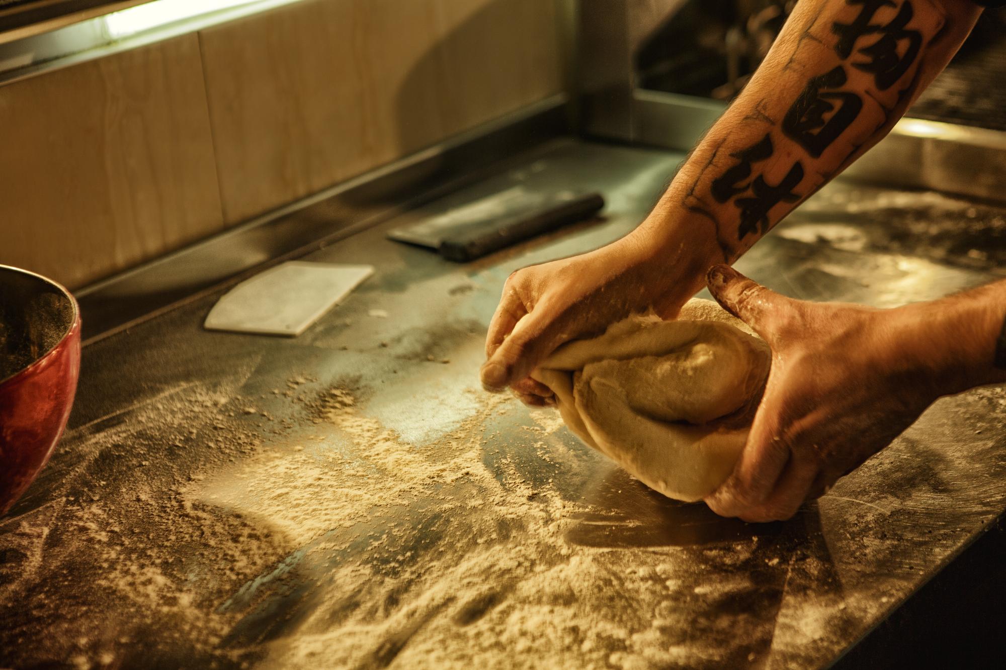 Close-up of hands kneading dough