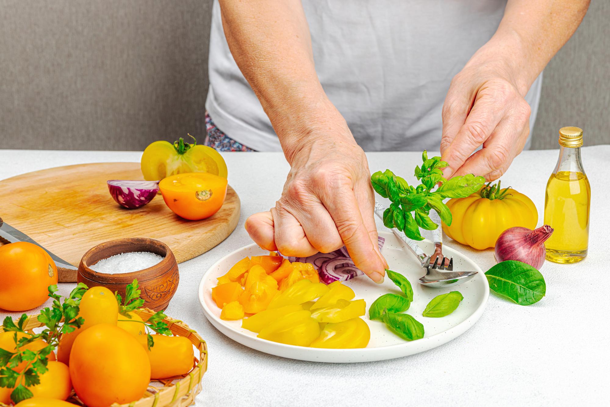Chef preparing a colorful local dish on a wooden table